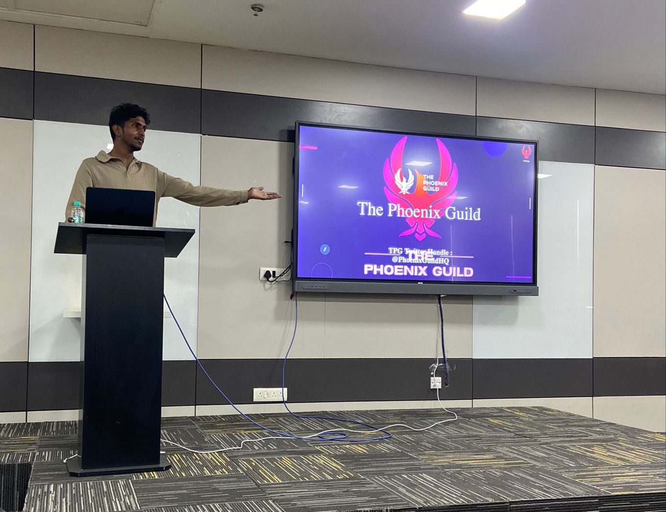 Jayanth Koppala at the podium while hosting the Aleo Chandigarh zkMeetup in Chandigarh, with The Phoenix Guild branding on screen.